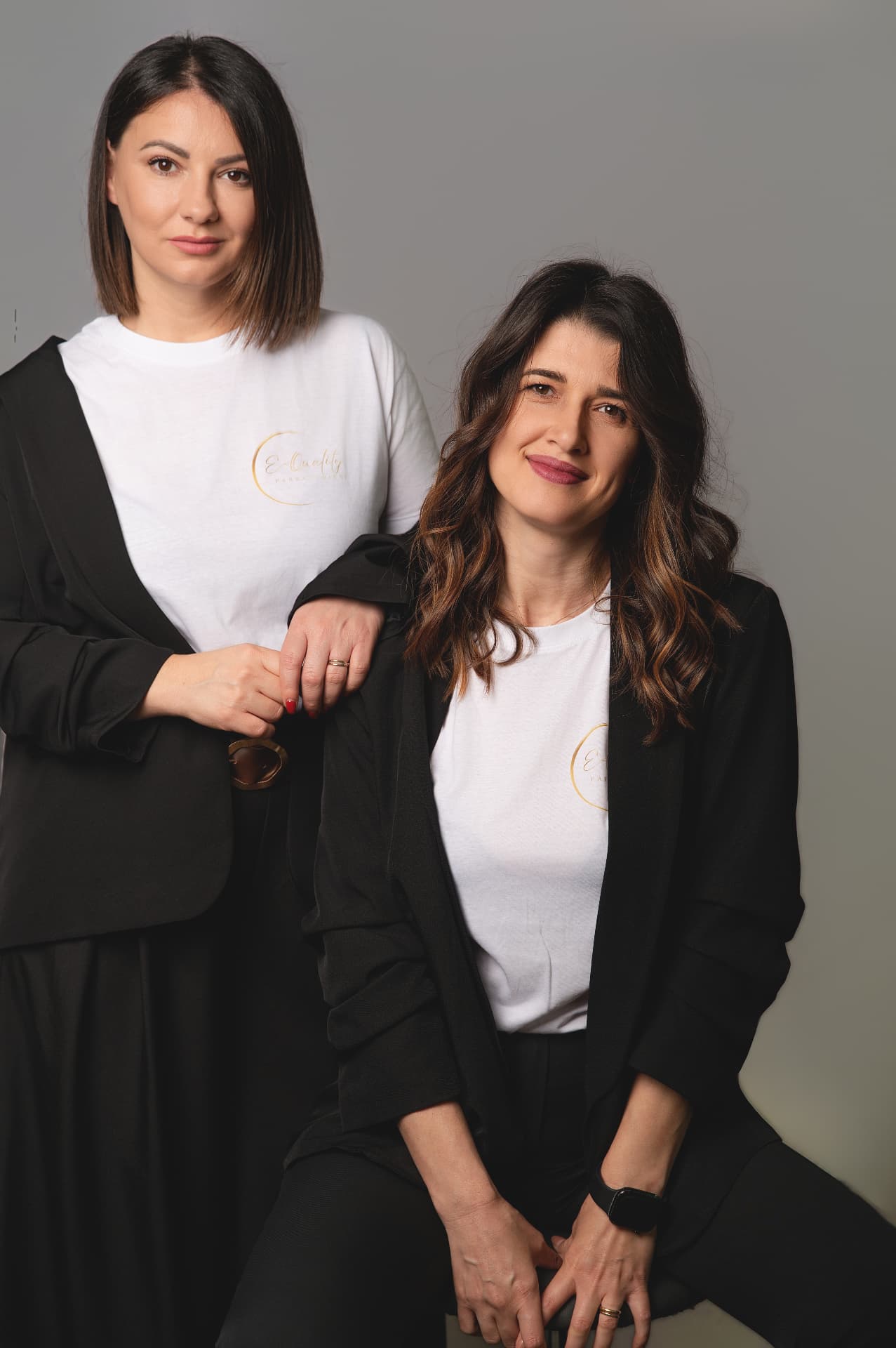 Matilda dhe Diana në studio, veshur me xhaketa të zeza mbi bluza të bardha